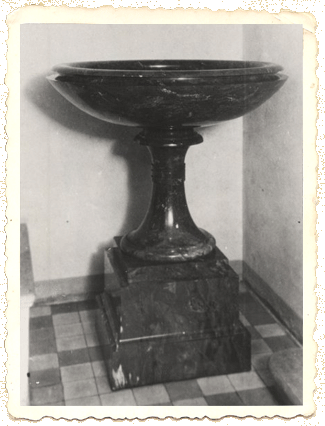 У столика покрытого длинной скатертью стояла ваза